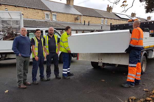 A fridge being loaded onto a wagon