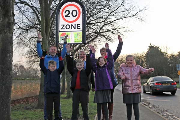 Children underneath a 20mph sign