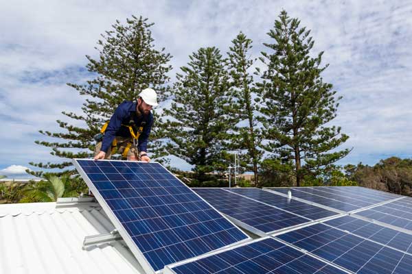 Man installing solar panels on a roof