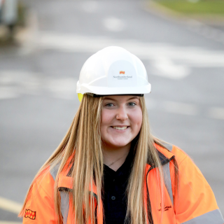 A female civil engineering apprentice smiling