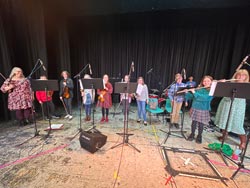 Students on stage preparing to play their instruments