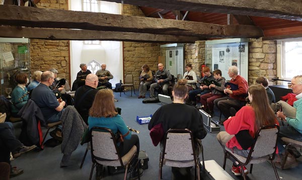 A group of people sitting in a circle with pipes