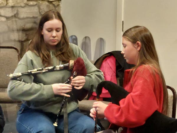 Two people setting up their pipes