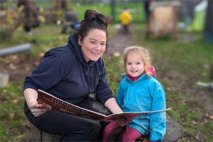 woman with little girl looking at book